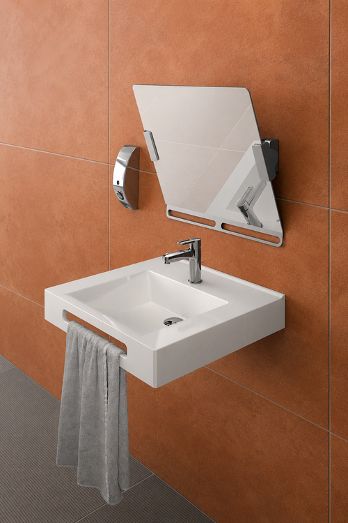 Miroir inclinable chromé AKW installé au-dessus d’une vasque dans une salle de bains accessible PMR.